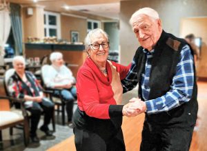 Senior couple dancing and smiling.