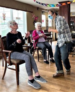 Two older women participating in a laughter yoga instructor.