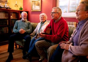 Old folks playing guitar and singing in the guest room