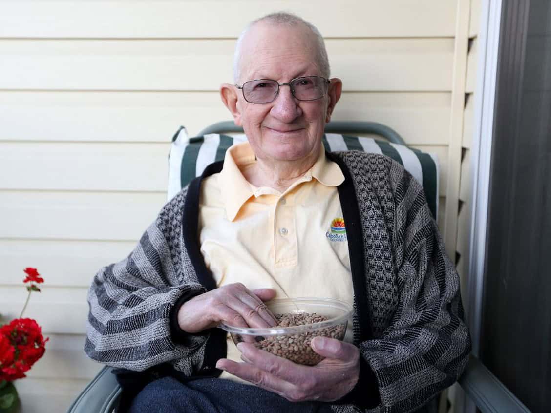 Famous senior man holding bowl of lentils